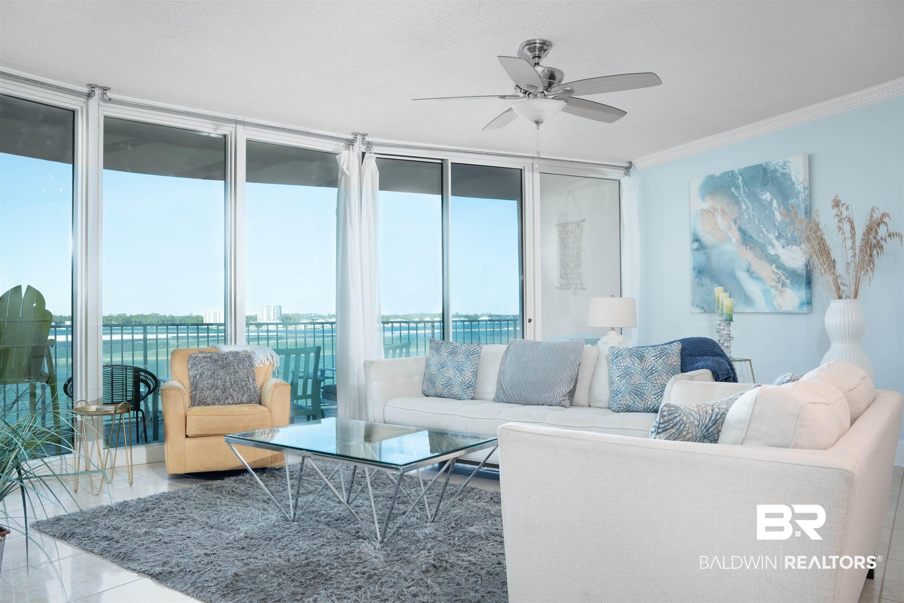 Image 2: Bright living space featuring expansive floor-to-ceiling windows, ceramic tile flooring, and crown molding