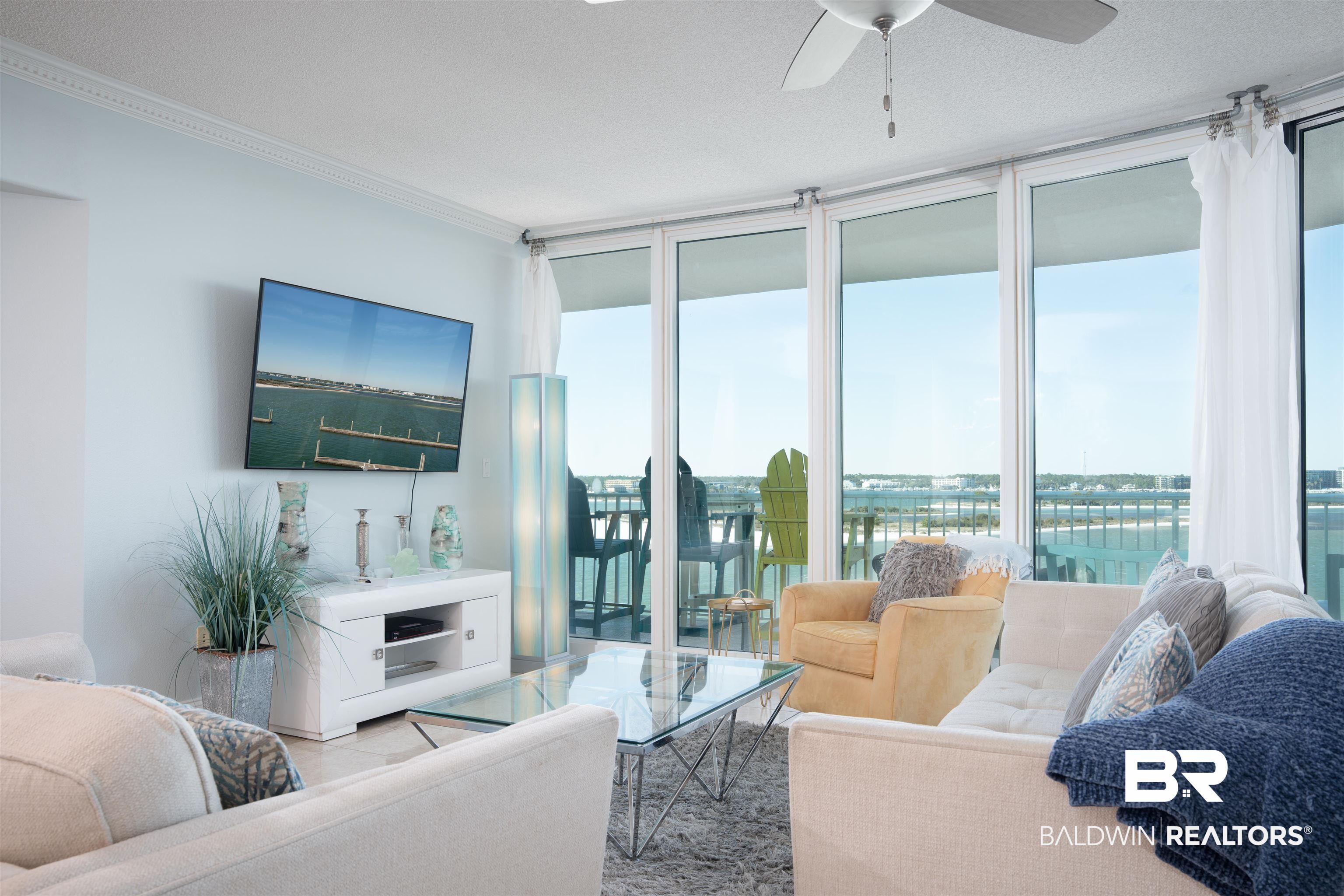 Image 3: Living area featuring floor-to-ceiling glass doors, crown molding, a ceiling fan, and tile flooring
