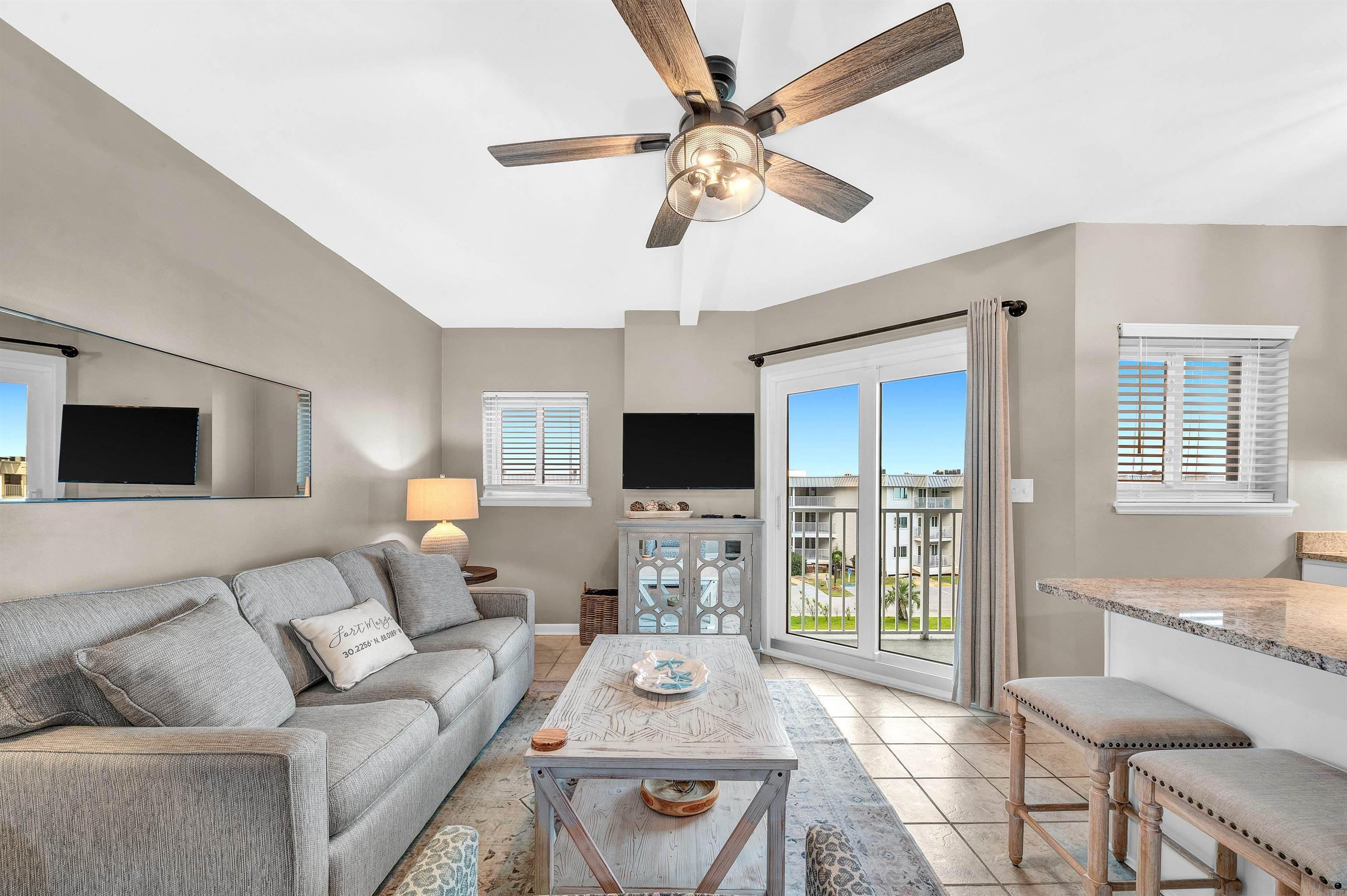Image 4: Living room featuring light tile patterned flooring and ceiling fan