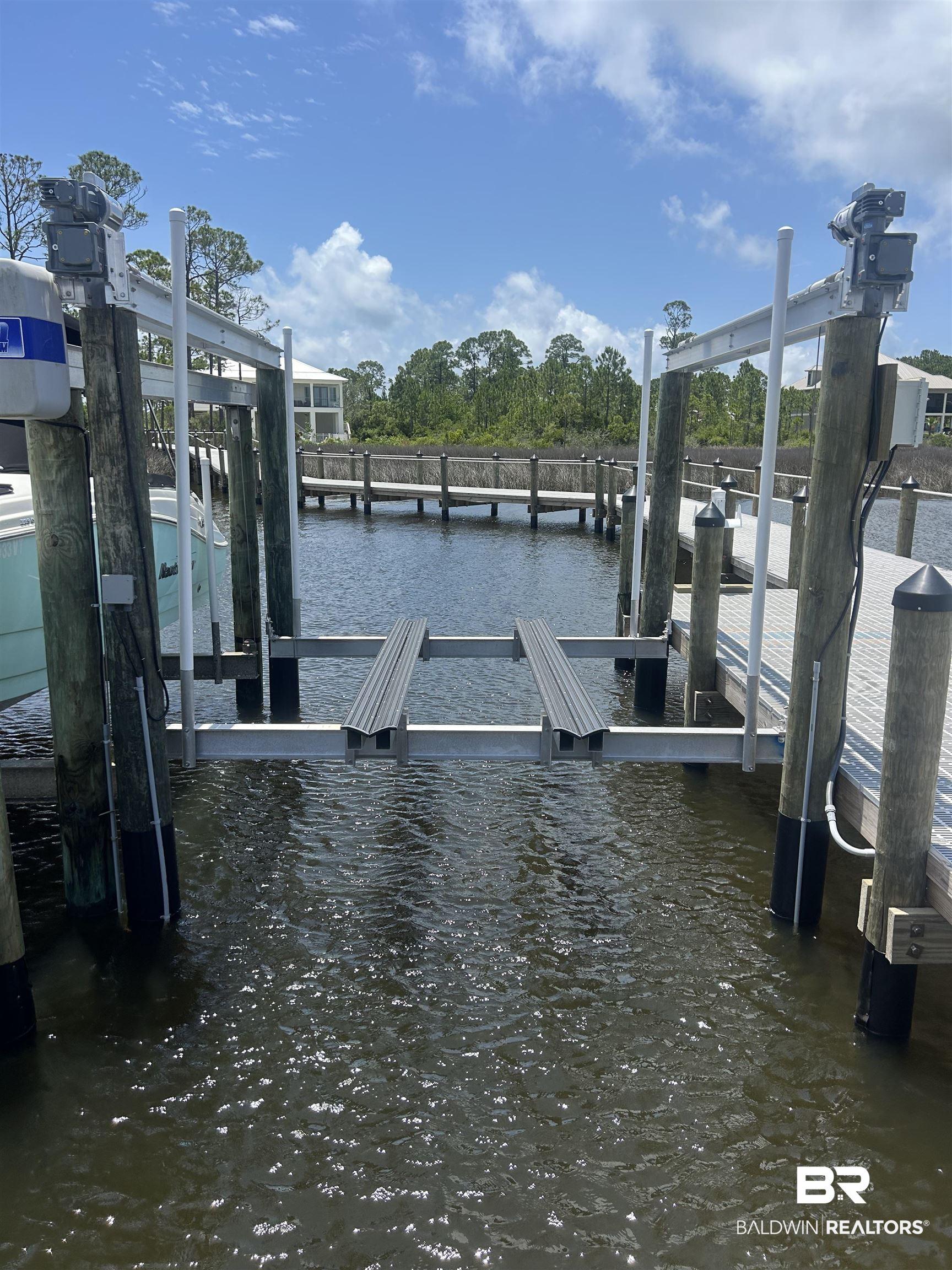 Image 3: Dock area featuring boat lift and a water view