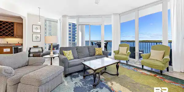 Image 2: Living room featuring expansive windows, wet bar, a ceiling fan, beverage cooler, and a water view