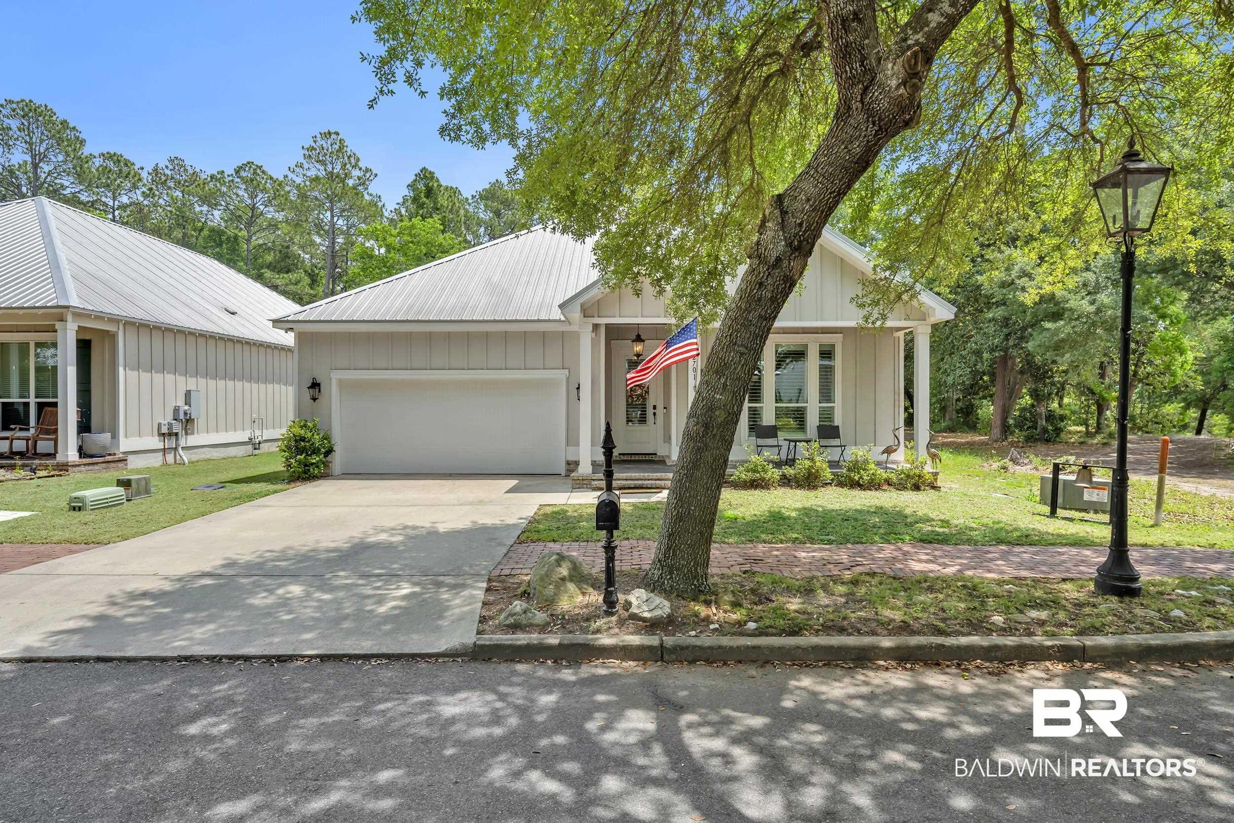 Image 4: Single-story residence featuring a metal roof, attached garage, and a covered front porch