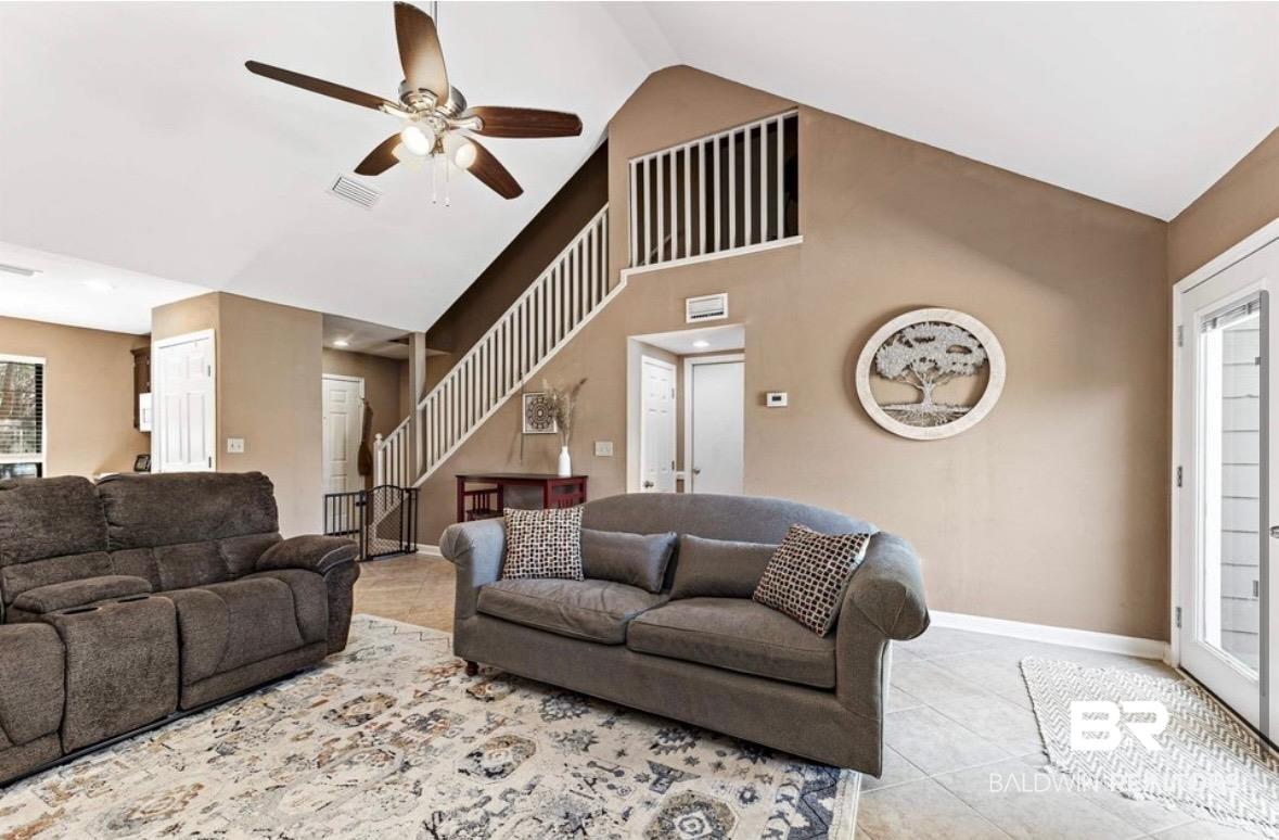 Image 4: Living room featuring a ceiling fan, light tile patterned floors, and a high ceiling