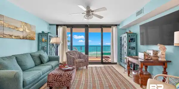 Image 4: Living area featuring expansive windows and ceiling fan
