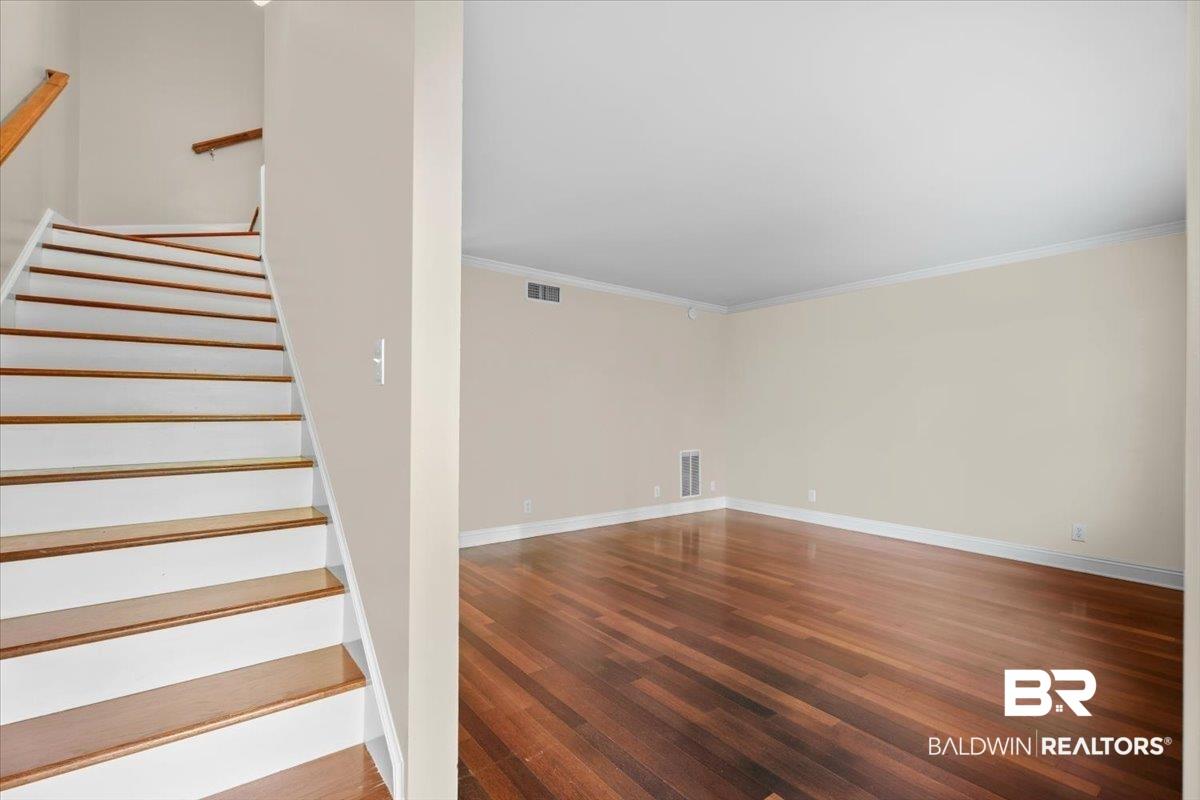 Image 4: Stairs with wood finished floors and ornamental molding