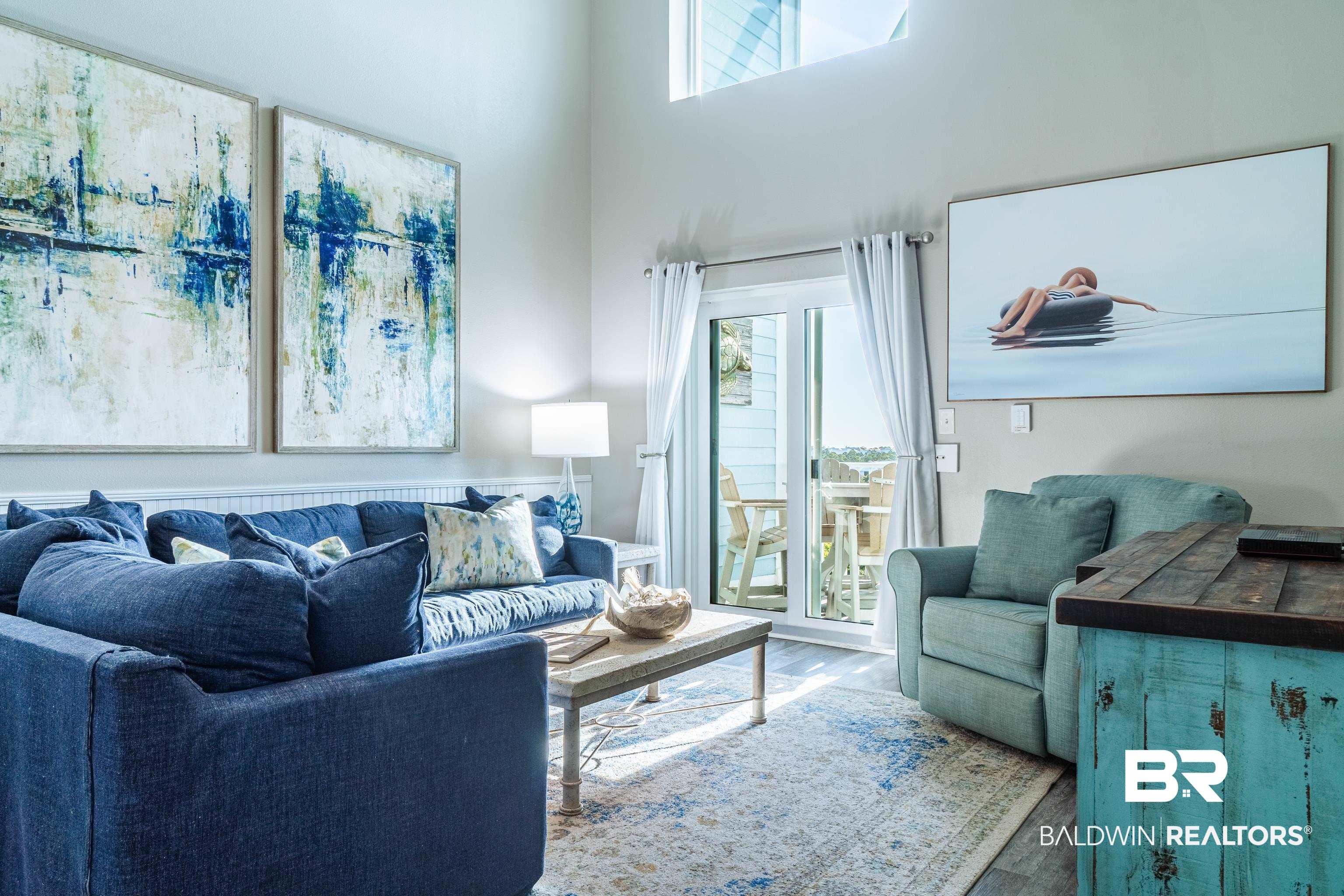 Image 3: Living room featuring a high ceiling and wood finished floors