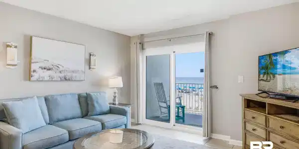 Image 4: Sliding glass doors open to an outdoor balcony with metal railings and expansive ocean scenery