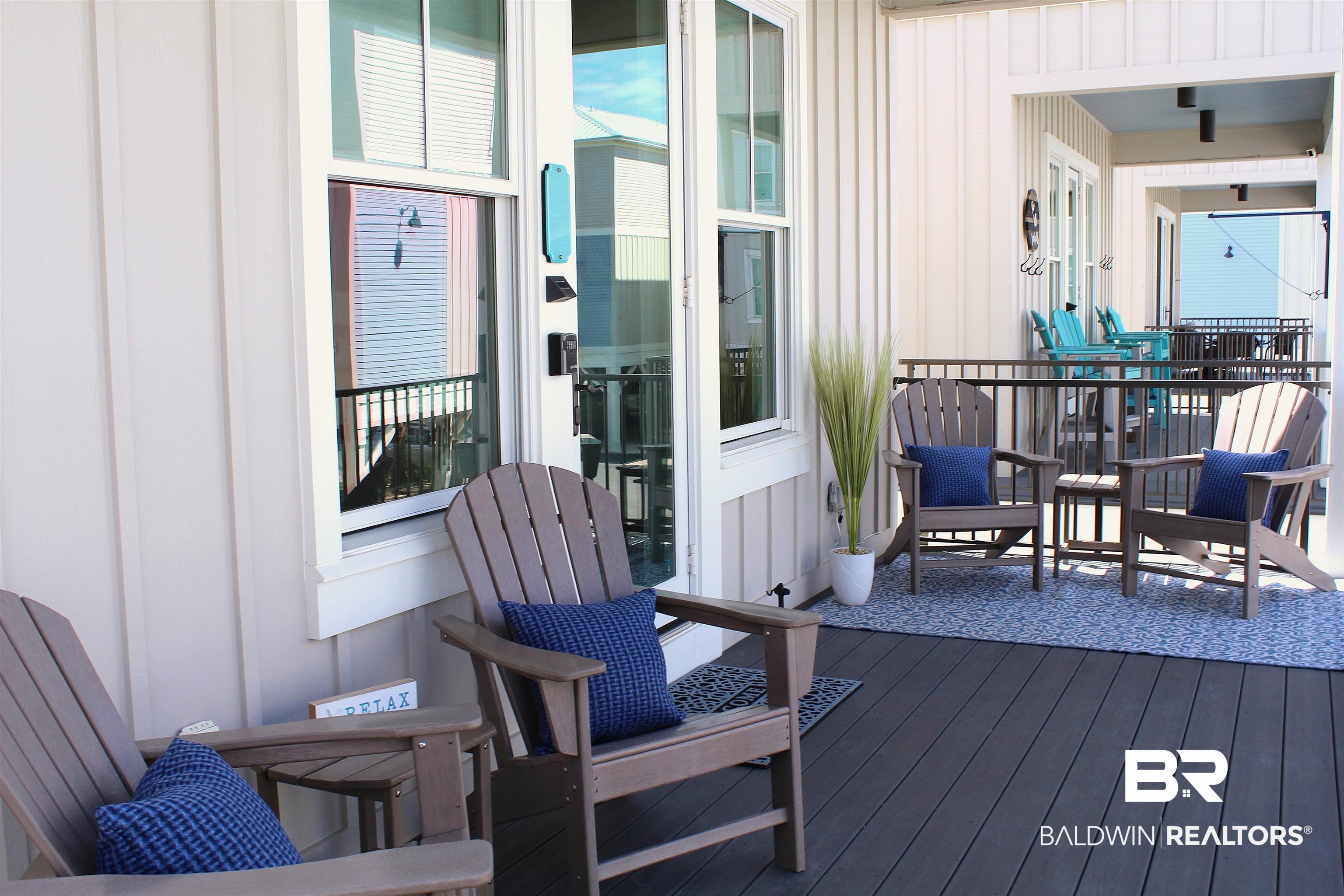 Image 2: Expansive outdoor deck featuring dark-toned composite flooring, white vertical siding, and multiple windows