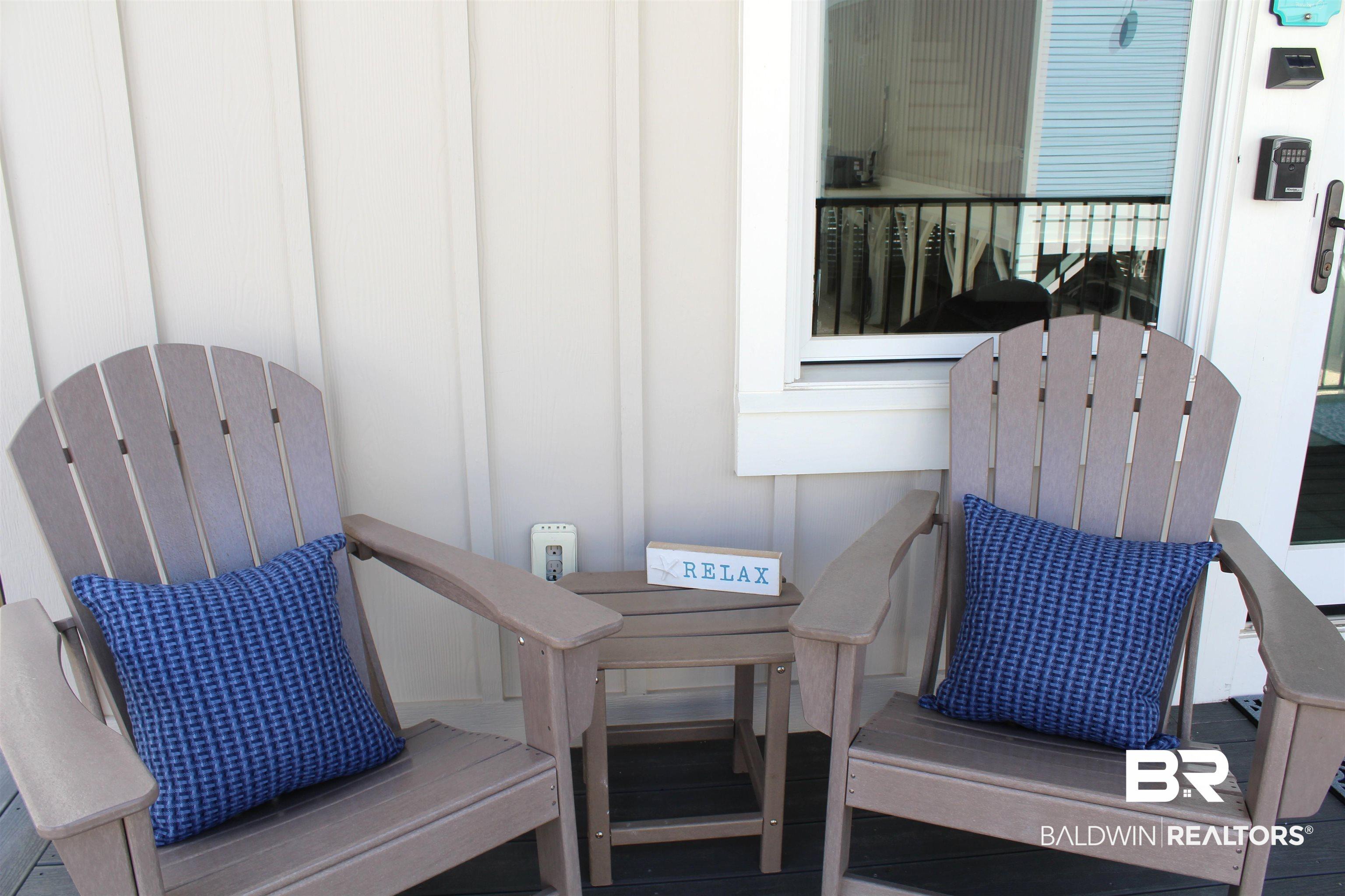 Image 3: Front porch with vertical plank siding, a white-trimmed window, and a dark-paneled door with a brushed nickel handle