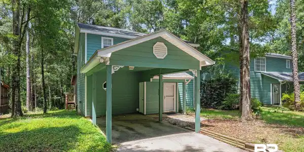 Image 2: Two-story home with a carport and dedicated storage area