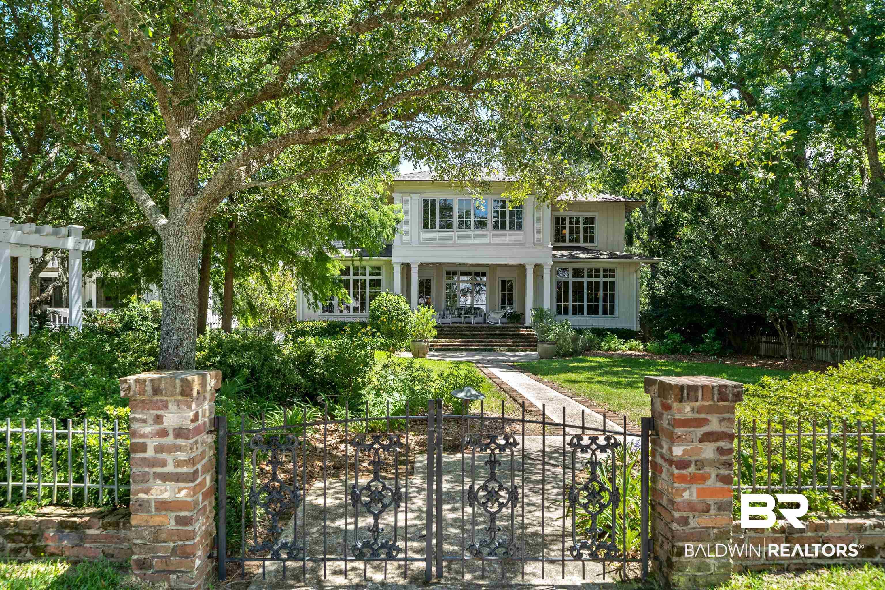 Image 2: View of front of house with a fenced front yard and a gate