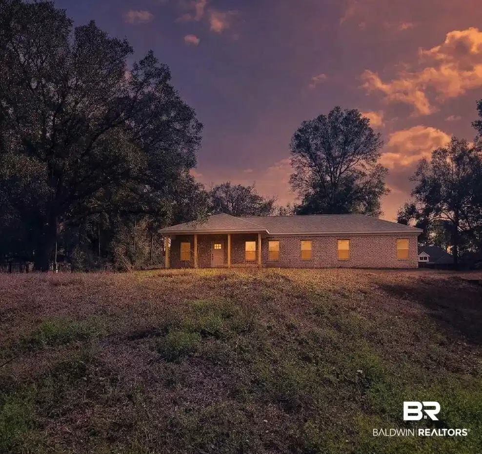 Image 1: Brick exterior residence featuring a covered front porch with four columns, a gabled roofline seating on the high area of almost 0.7 acres