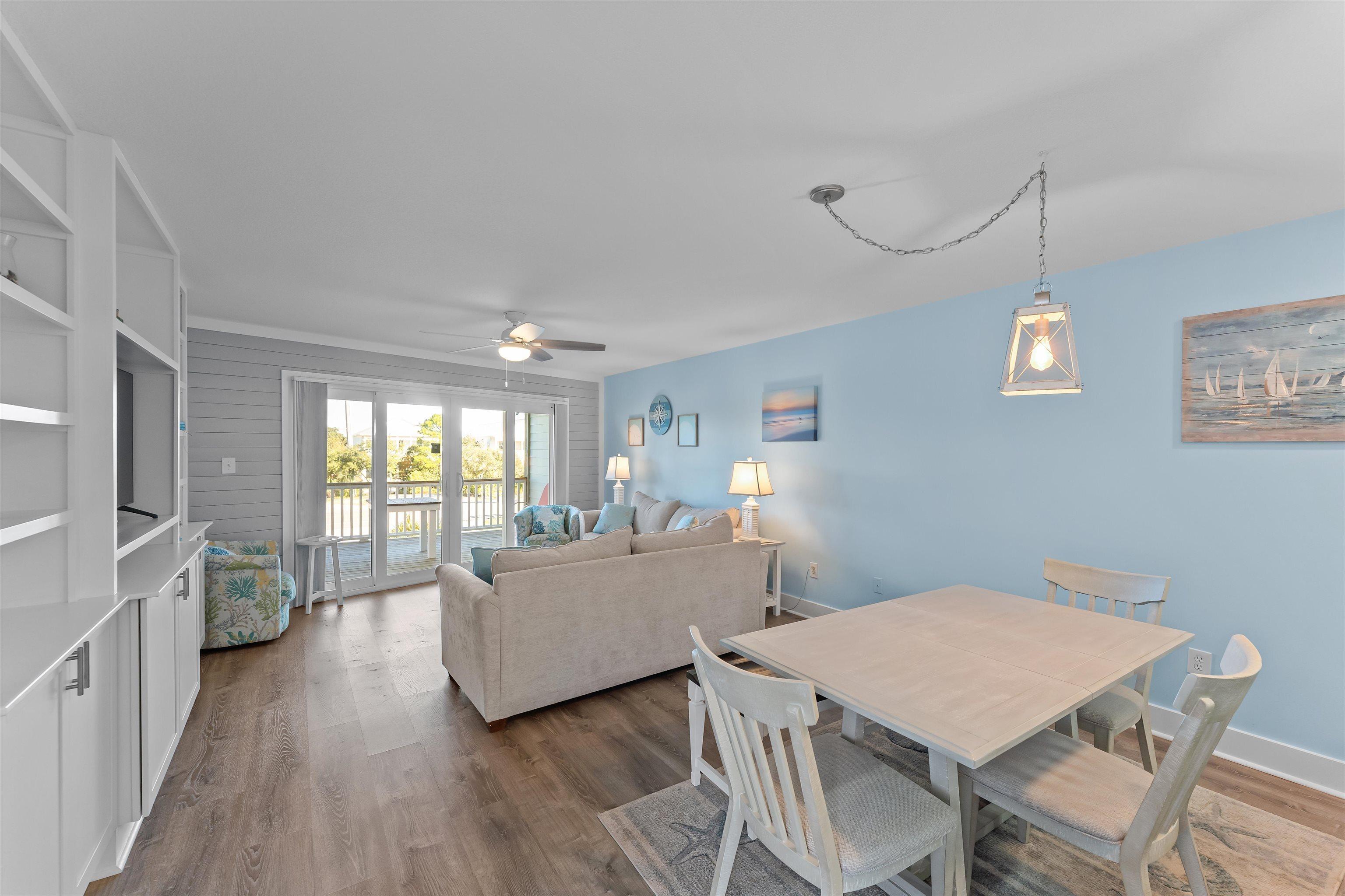 Image 4: Dining area featuring light wood finished floors, a ceiling fan, and wooden walls