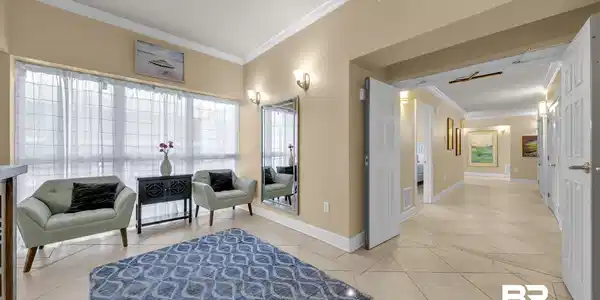 Image 4: Spacious entry area featuring light-toned tile flooring, tall baseboards, and crown molding