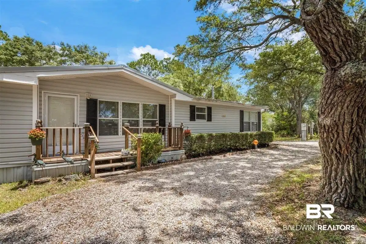 Image 1: Light-colored horizontal siding exterior with dark shutters