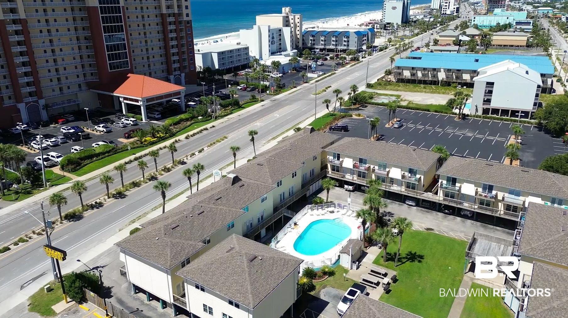 Image 1: View of urban area featuring a pool area and a nearby body of water
