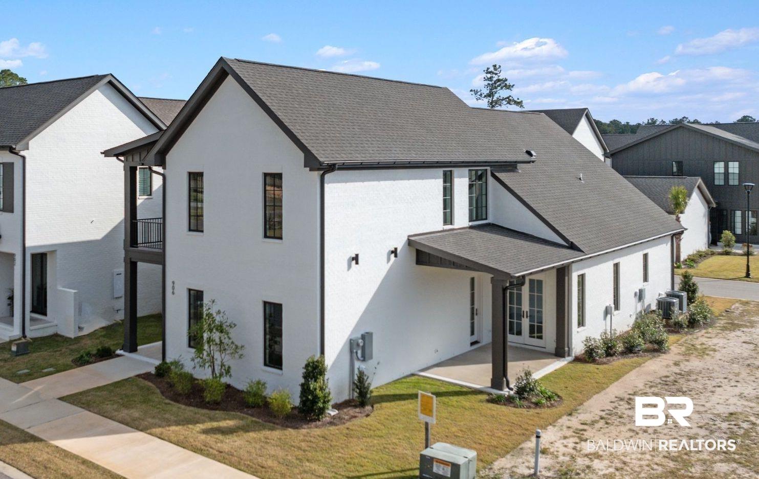 Image 1: Rear view of property with a yard, french doors, and brick siding