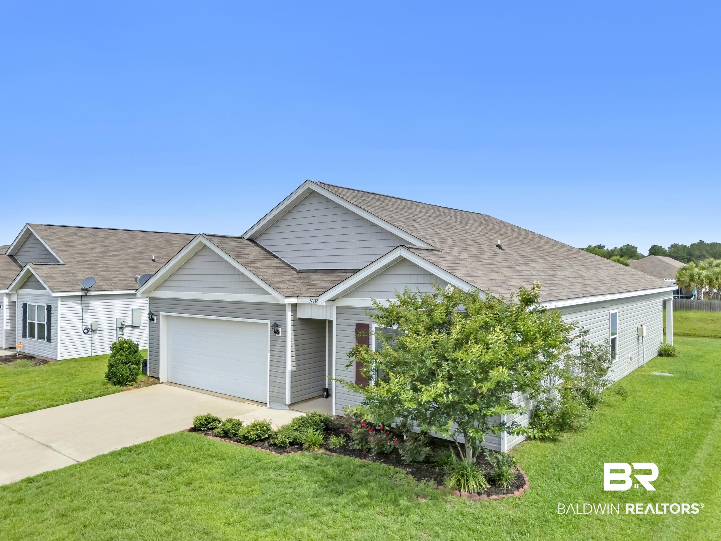 Image 3: Single-story home featuring light gray siding with white trim accents and a dark roof
