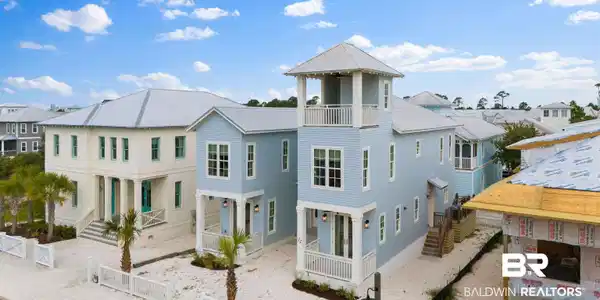 Image 2: Coastal-inspired architecture featuring light blue siding and a prominent observation tower with an upper-level balcony