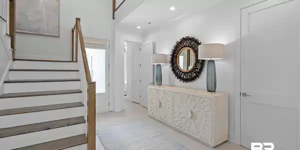 Image 4: Two-story foyer featuring wood-finish flooring, white walls, and a staircase with wood-finish handrails and treads