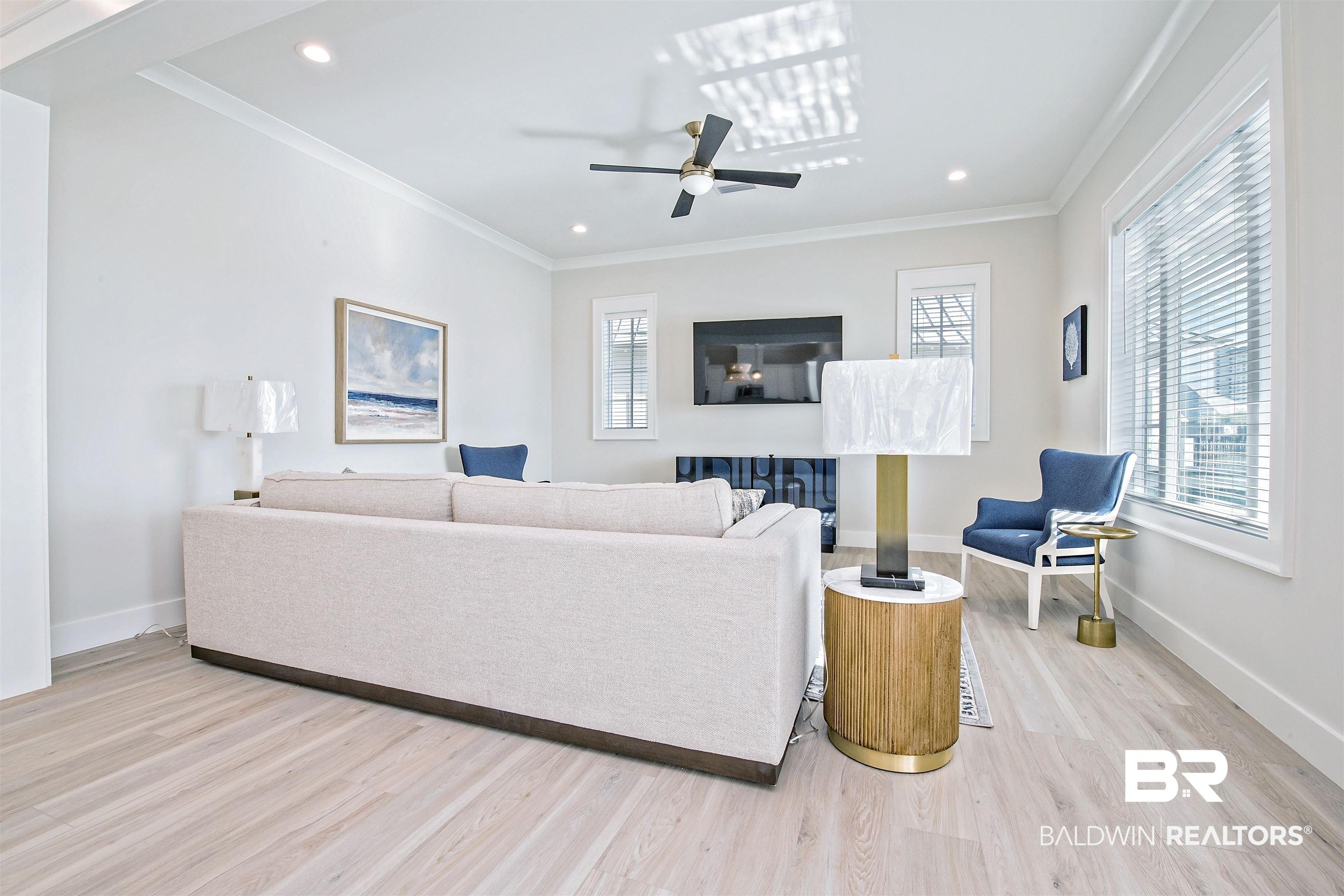 Image 3: Living room with ceiling fan, ornamental molding, a healthy amount of sunlight, and light hardwood / wood-style flooring