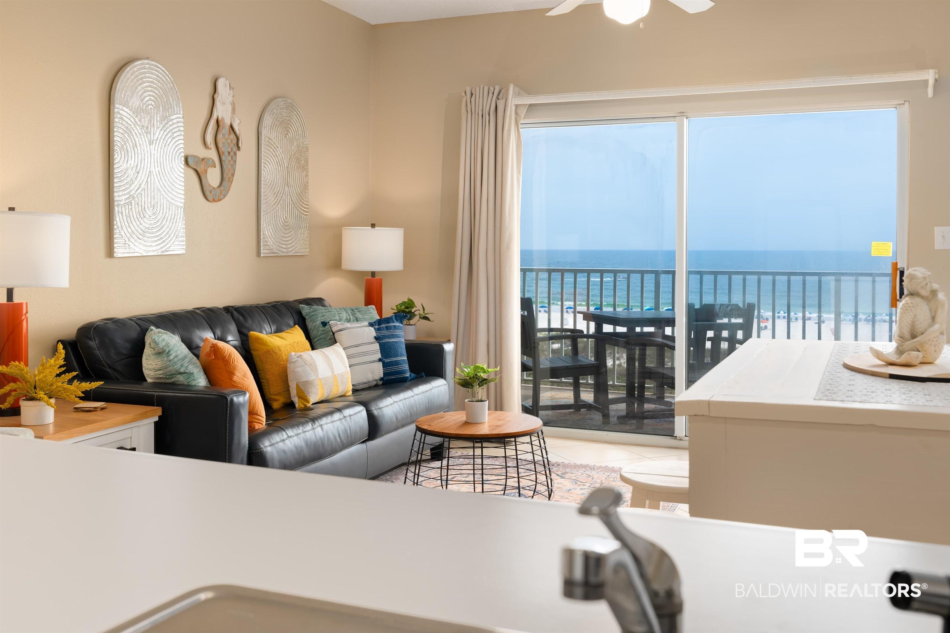 Image 4: Living area with a water view, light tile patterned flooring, and ceiling fan