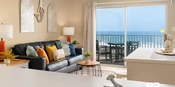 Image 4: Living area with a water view, light tile patterned flooring, and ceiling fan