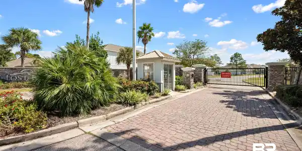 Image 4: View of road featuring curbs, a gate, and a gated entry