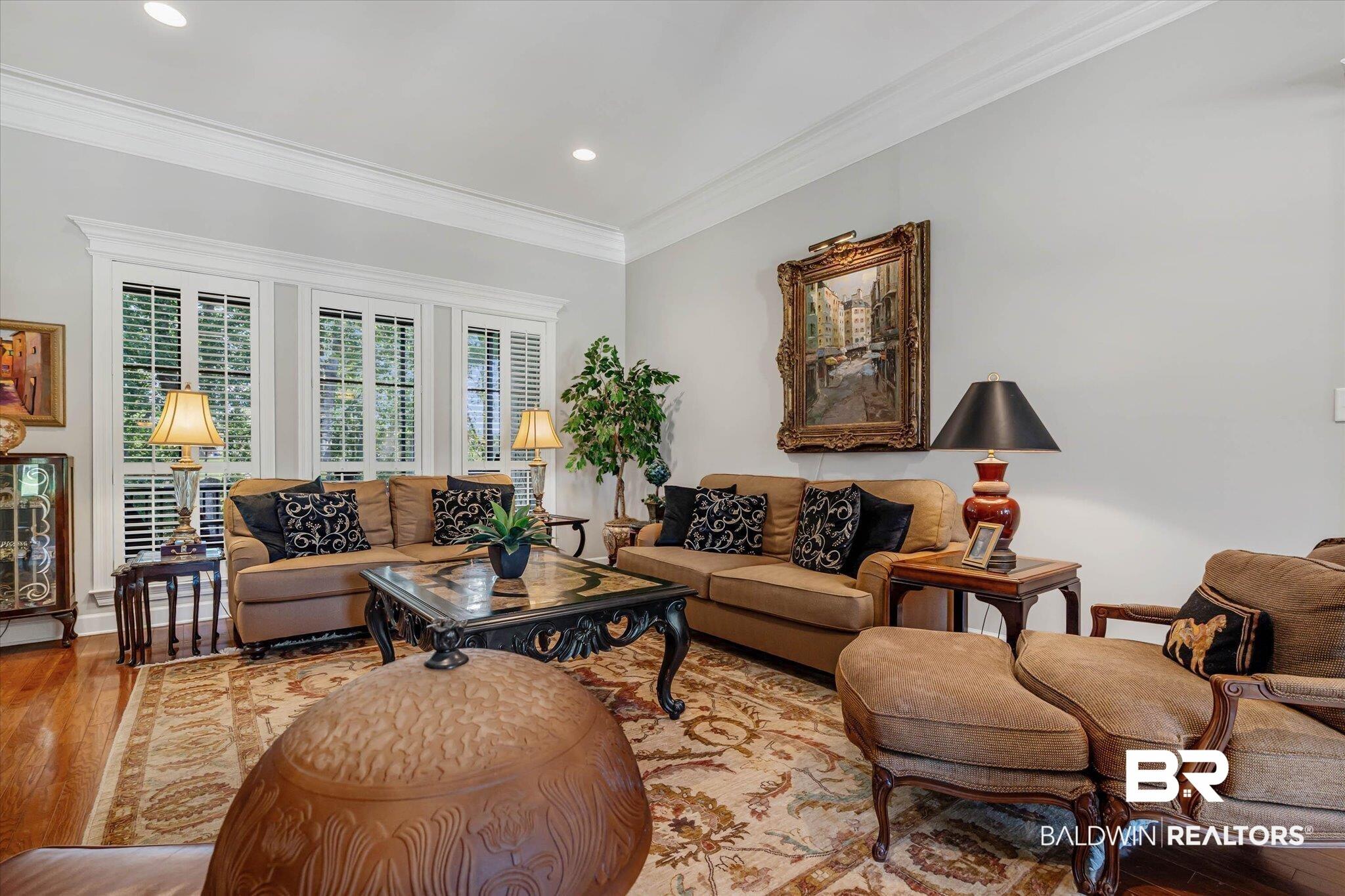 Image 4: Living area featuring wood-finish flooring, a decorative area rug, and recessed lighting