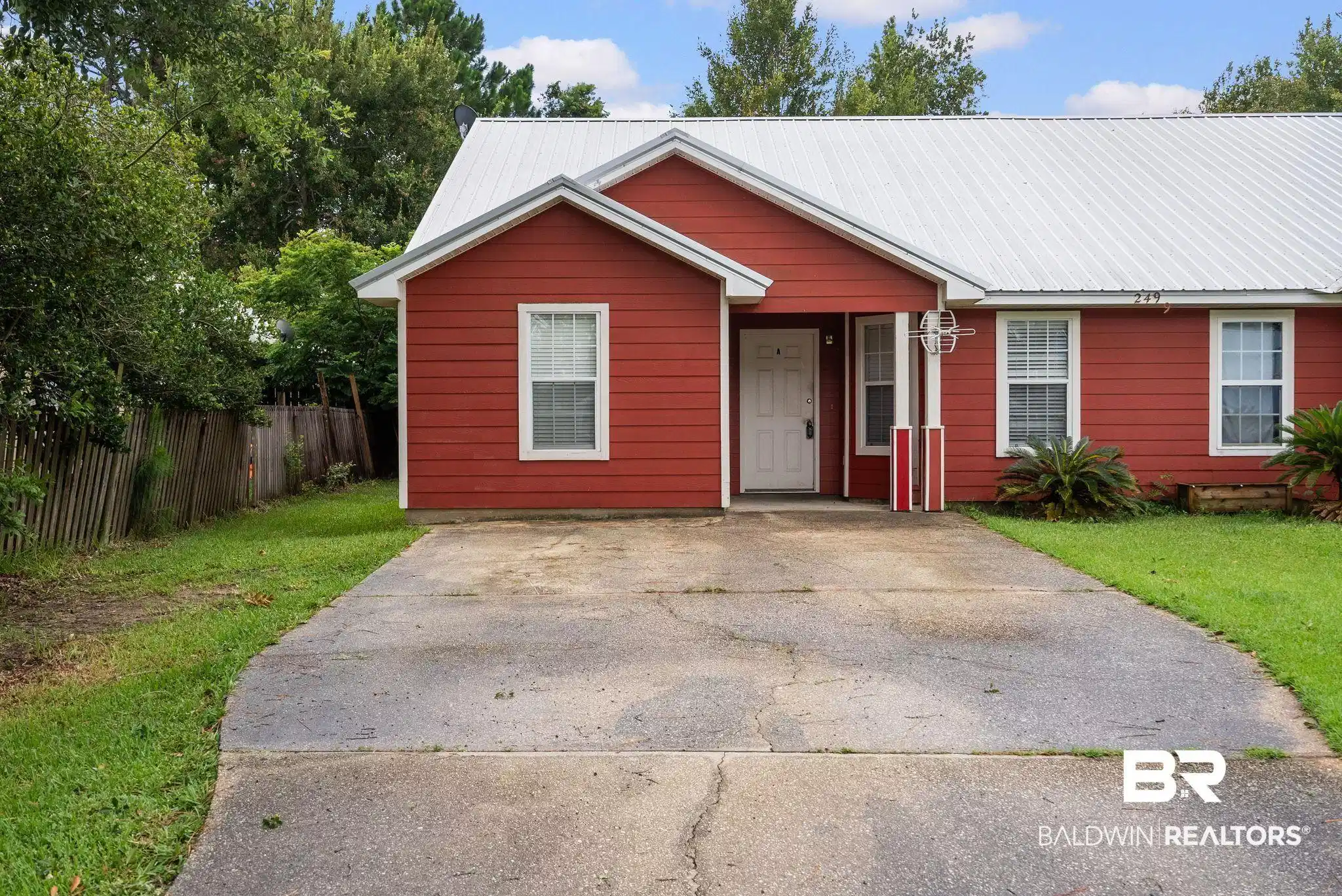 Image 1: Red siding exterior with white trim details and a contrasting white metal roof
