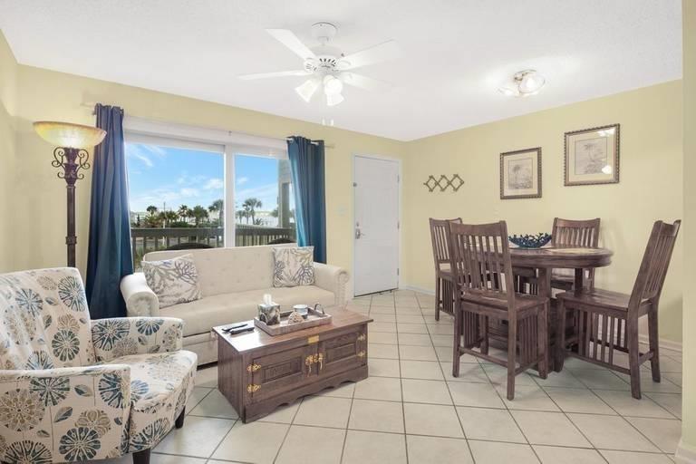 Image 4: Living room with baseboards, light tile patterned floors, and ceiling fan