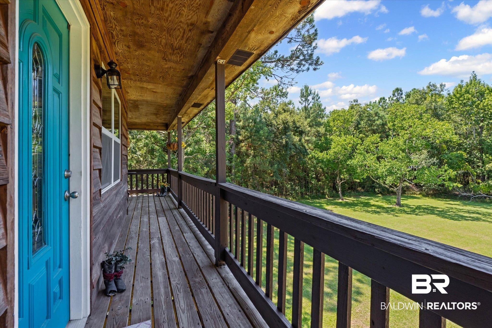 Image 2: Deck with view of wooded area and a lawn