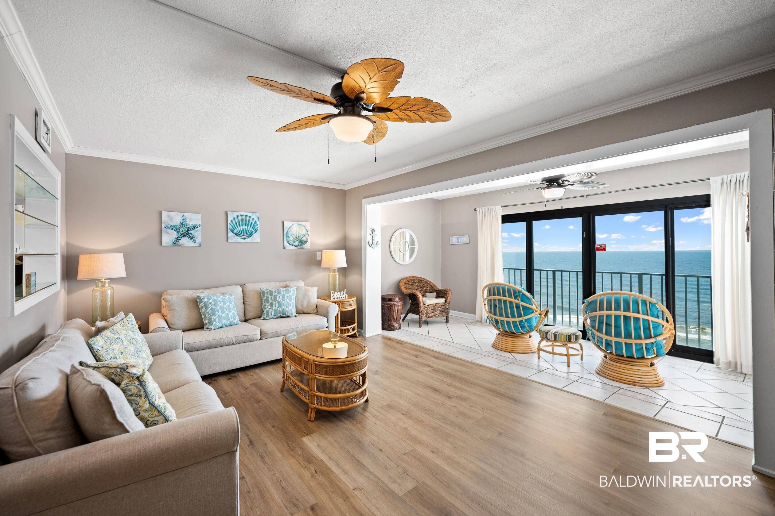 Image 4: Living area featuring crown molding, a water view, wood finished floors, ceiling fan, and a textured ceiling