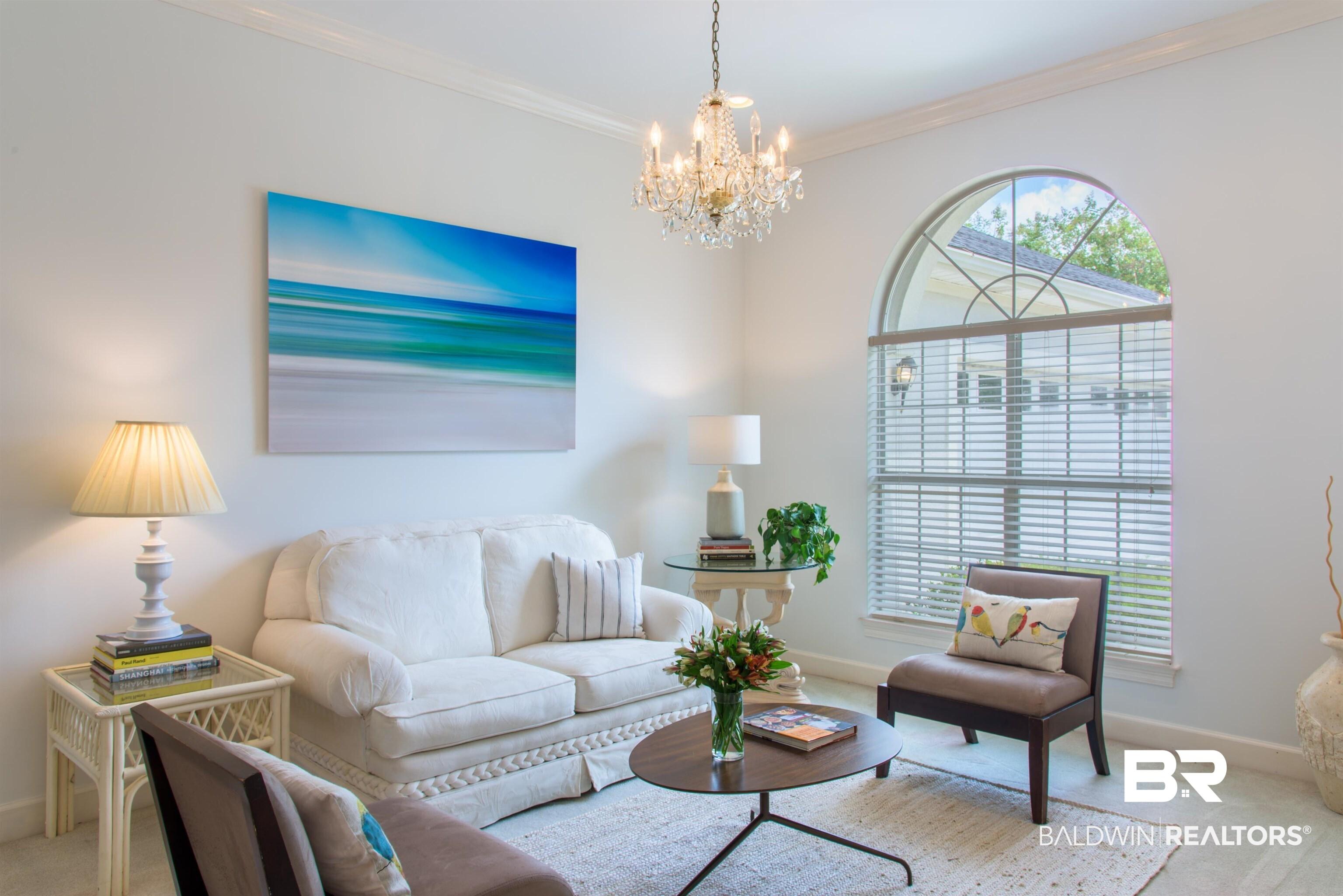 Image 4: Carpeted living room with hanging lights and ornamental molding