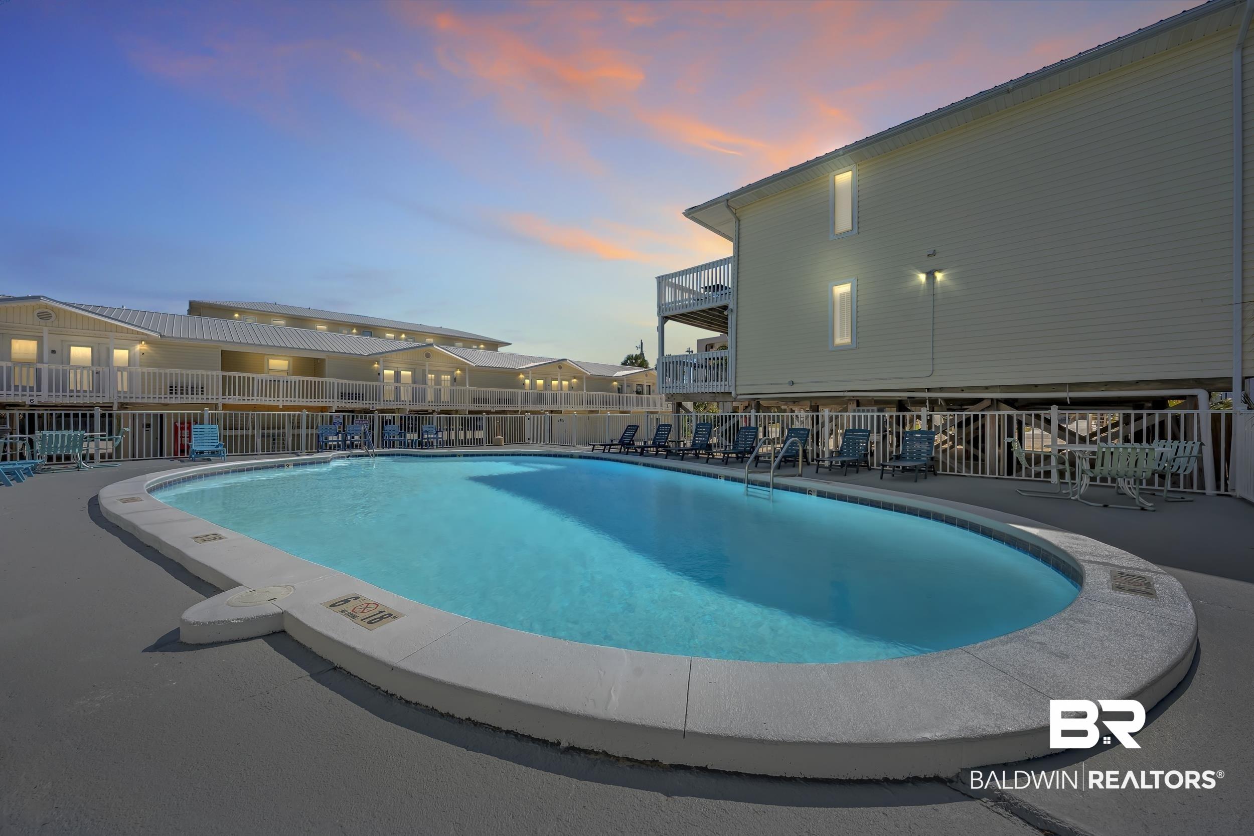 Image 4: Community pool with a patio area and a balcony