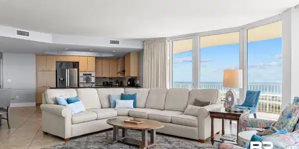 Image 3: Living area with a wall of windows, a water view, light tile patterned floors, and ceiling fan