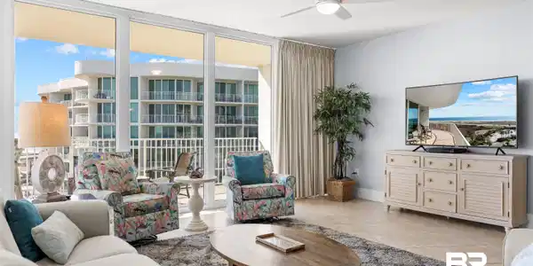 Image 4: Living area with healthy amount of natural light, light tile patterned floors, floor to ceiling windows, and a ceiling fan