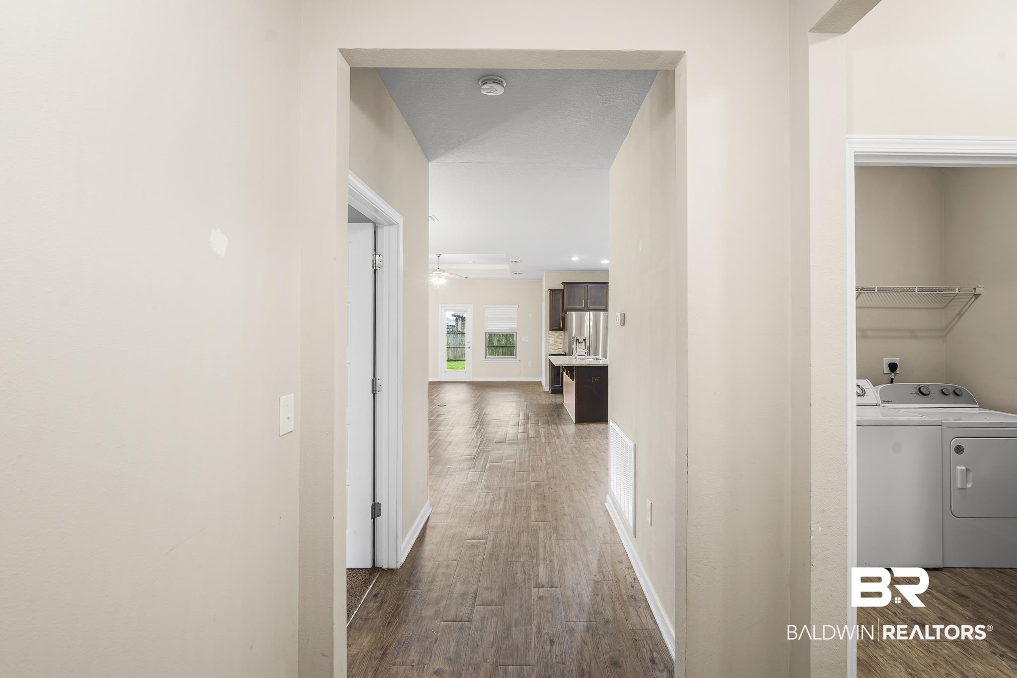 Image 4: Hallway with wood-finish flooring, light-toned walls, and a recessed ceiling light