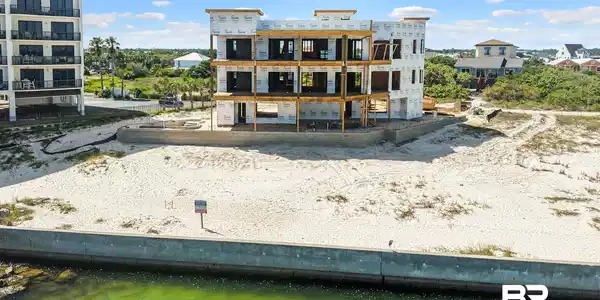 Image 4: Three-story residential structure under construction featuring exposed framing and a waterproof membrane