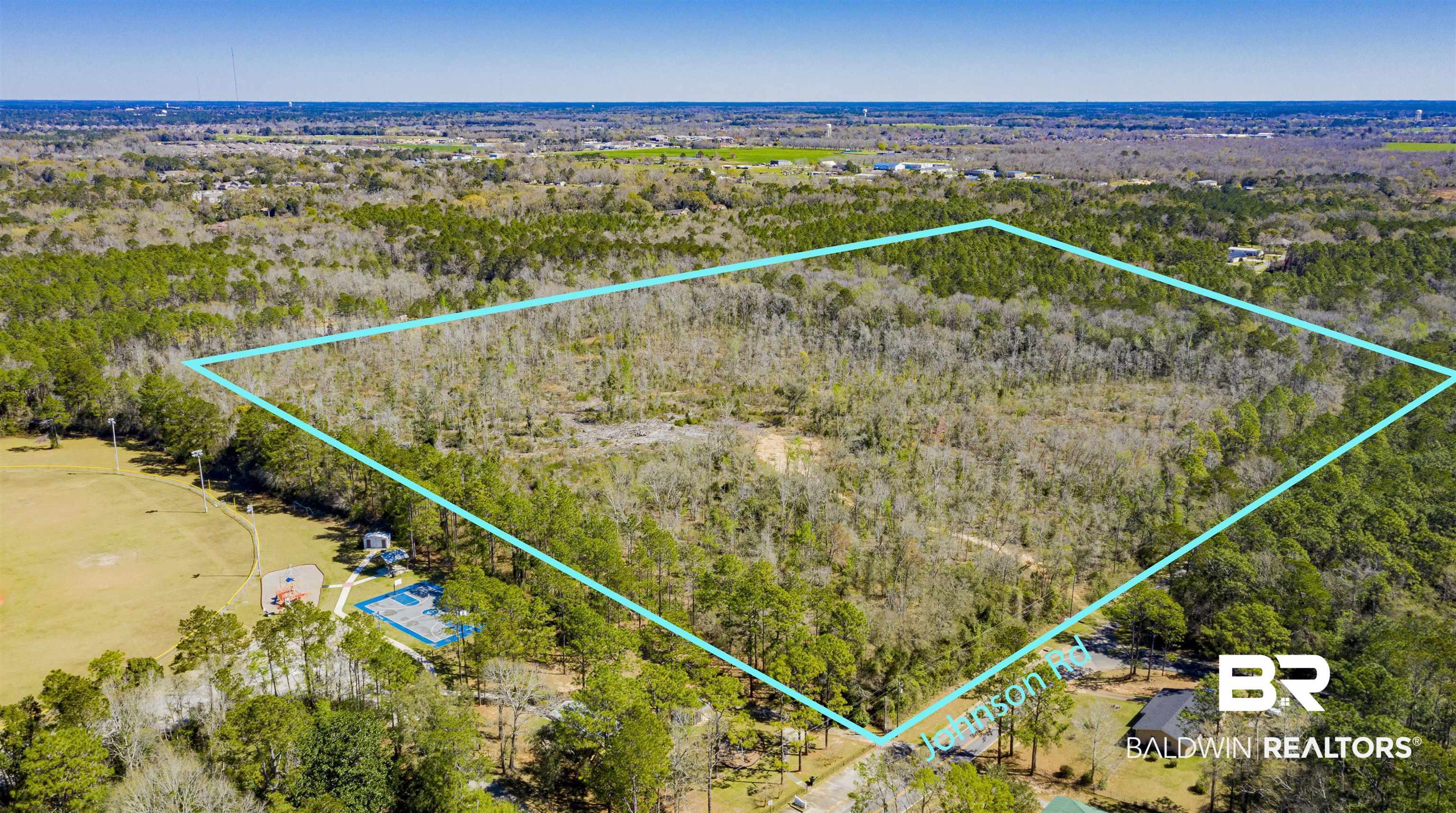 Image 1: Aerial view of property's location with a heavily wooded area and property parcel outlined