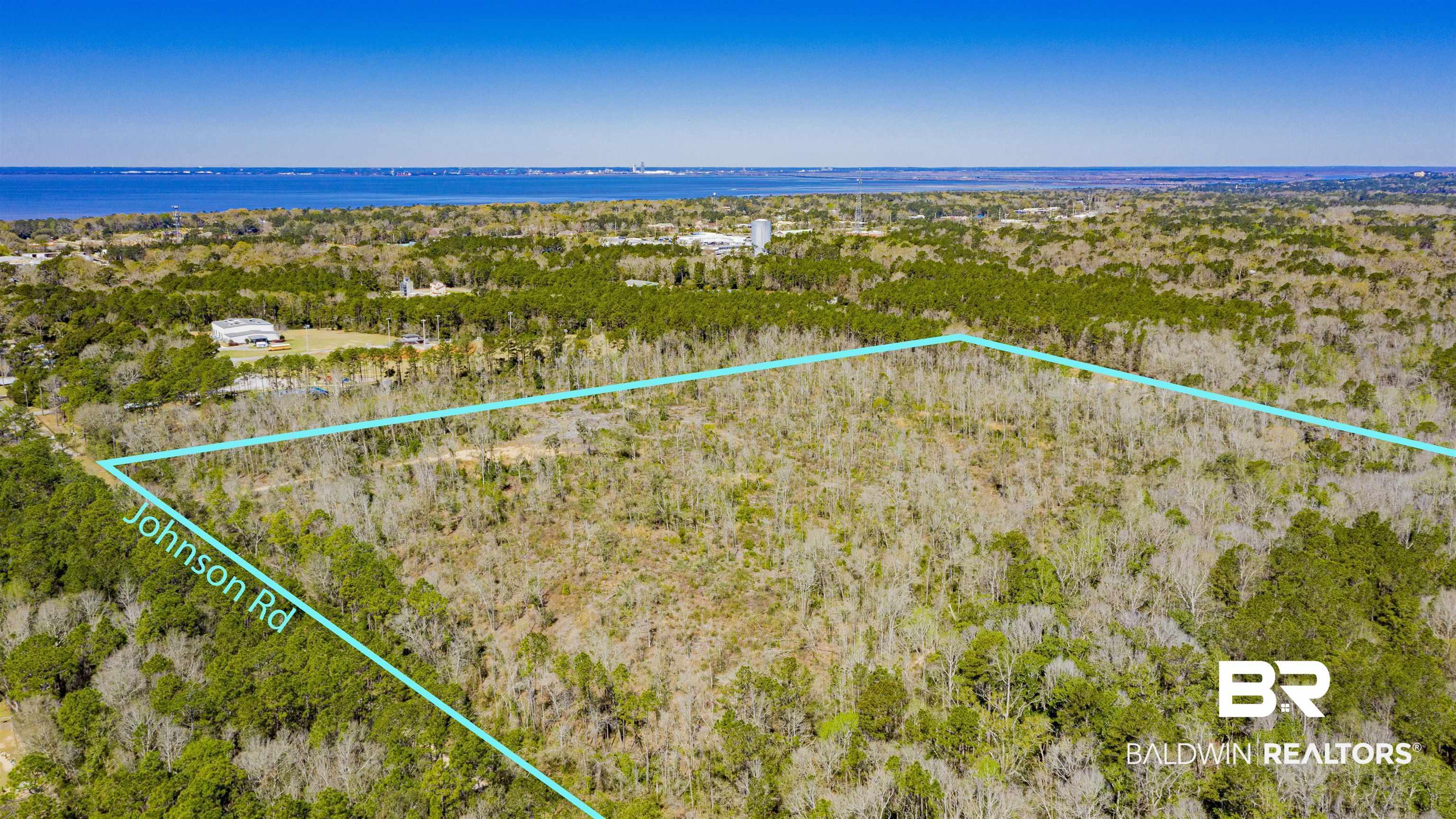 Image 3: Aerial view of property and surrounding area with property parcel outlined and a large body of water
