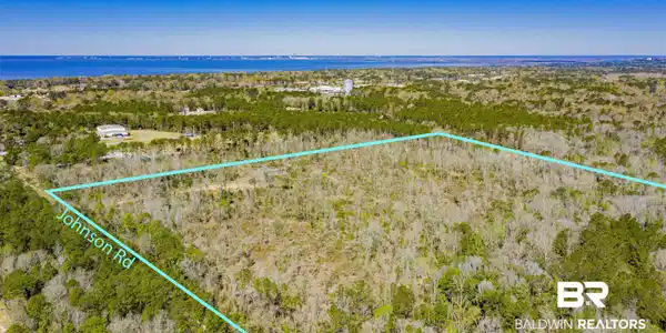 Image 3: Aerial view of property and surrounding area with property parcel outlined and a large body of water