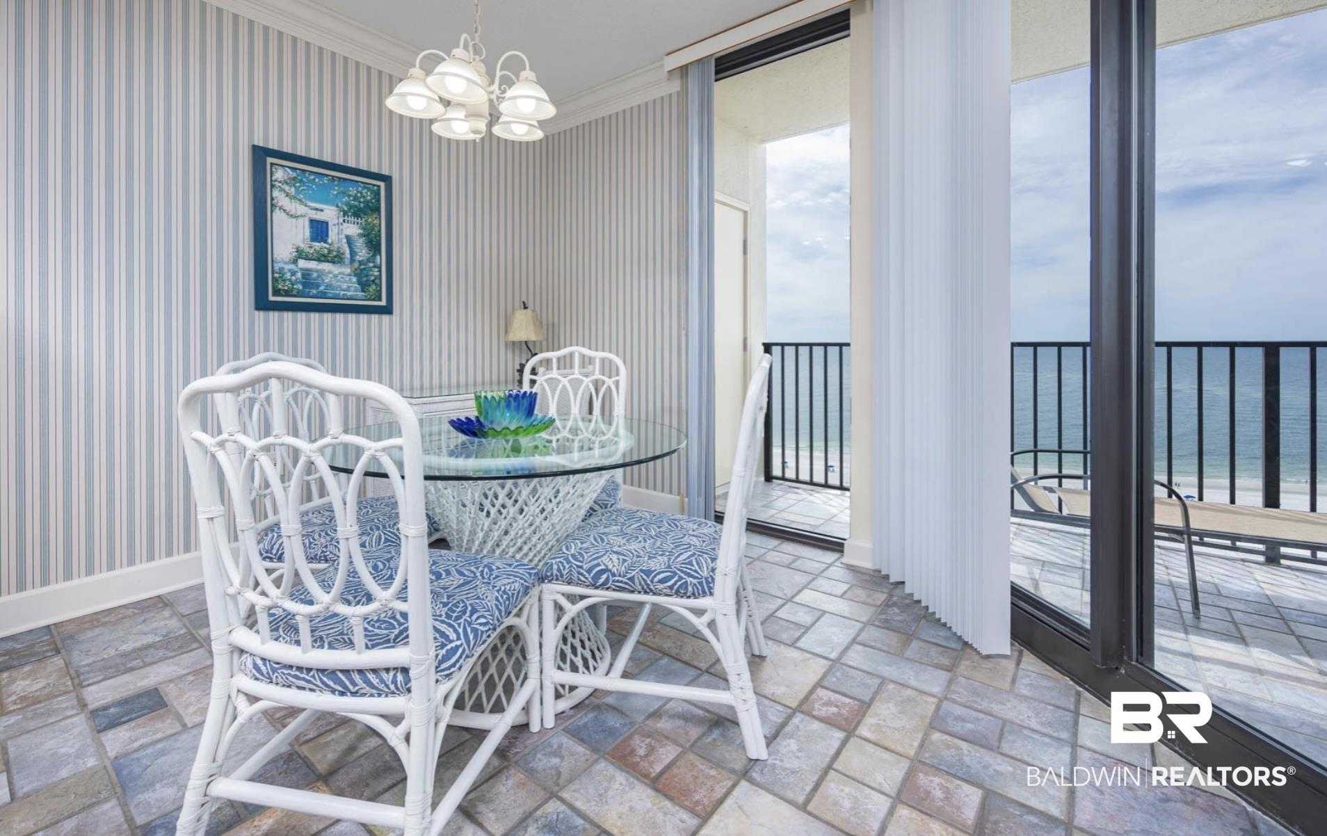 Image 4: Dining area featuring a water view, crown molding, and an inviting chandelier