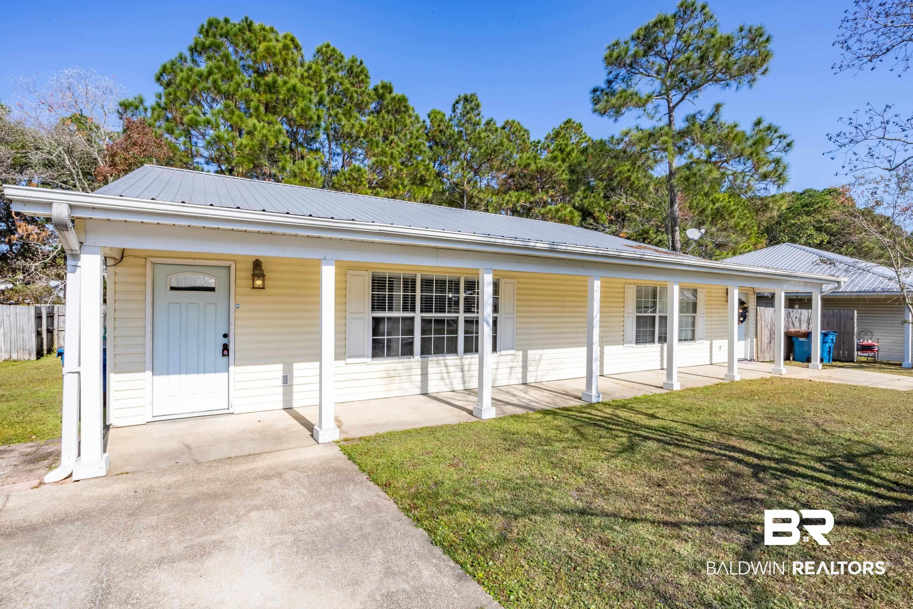 Image 2: View of front of home with covered porch and a metal roof