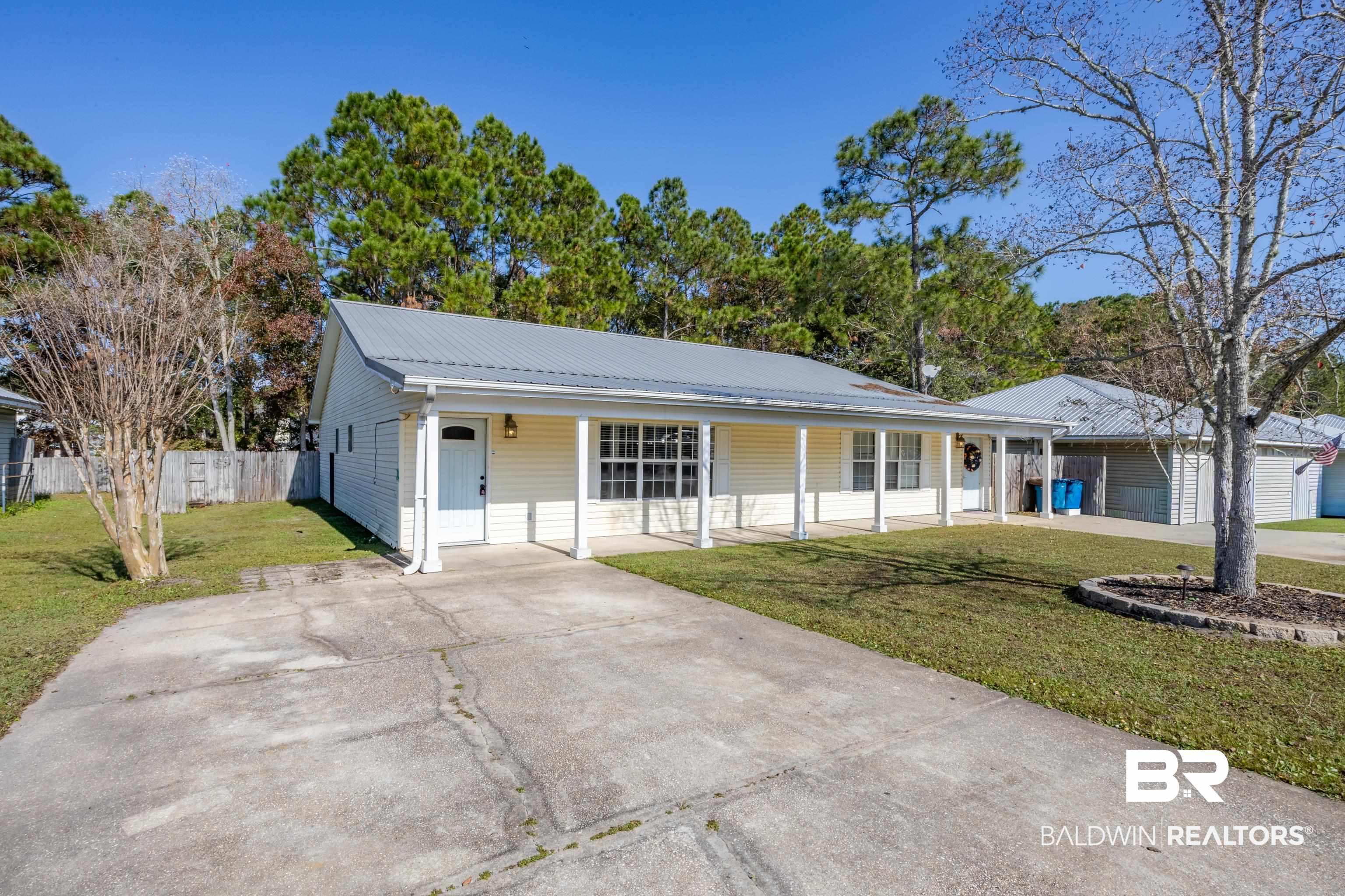 Image 3: Single story home featuring a metal roof, a porch, and concrete driveway