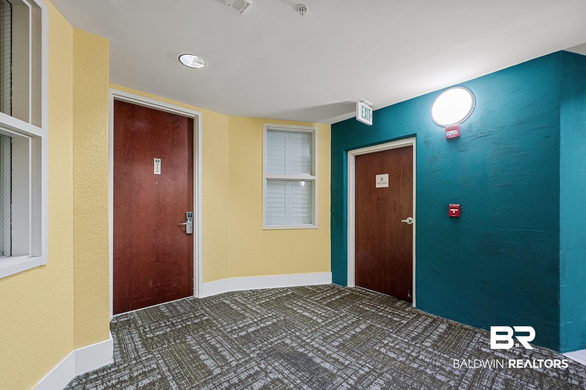 Image 2: Carpeted foyer featuring a textured wall