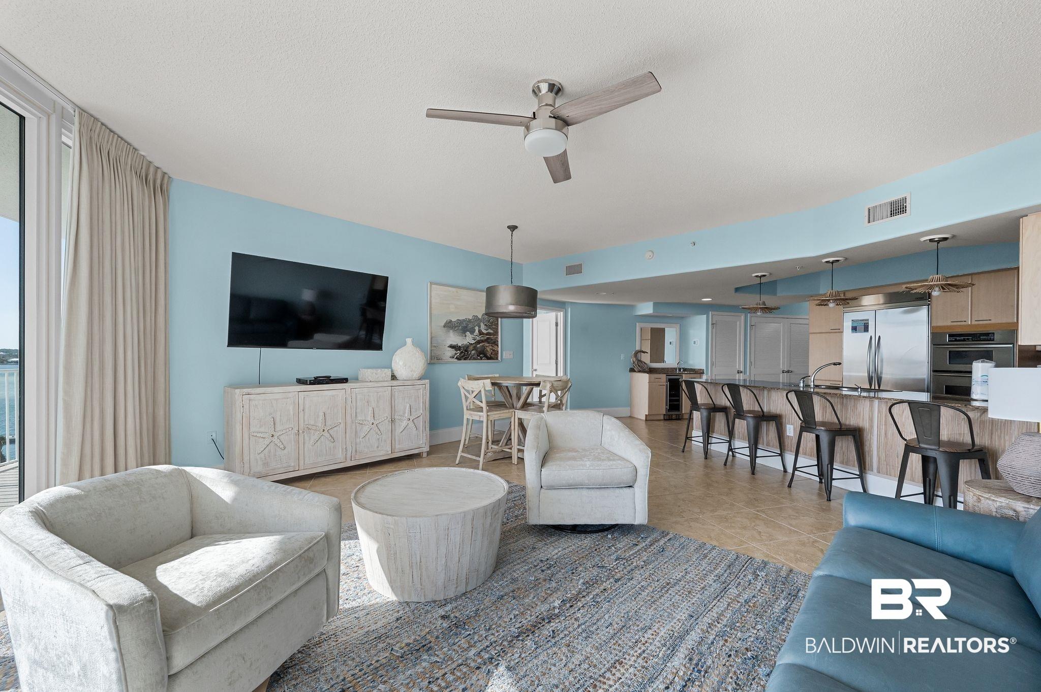 Image 3: Living area featuring a ceiling fan and light tile patterned floors
