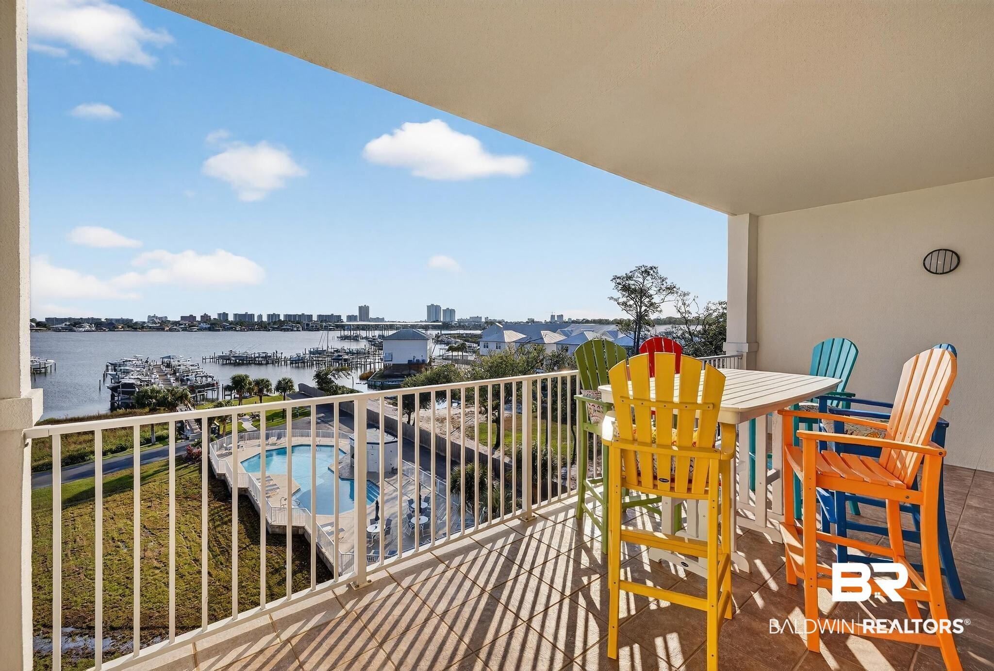Image 2: Balcony featuring view of pool area and a water view