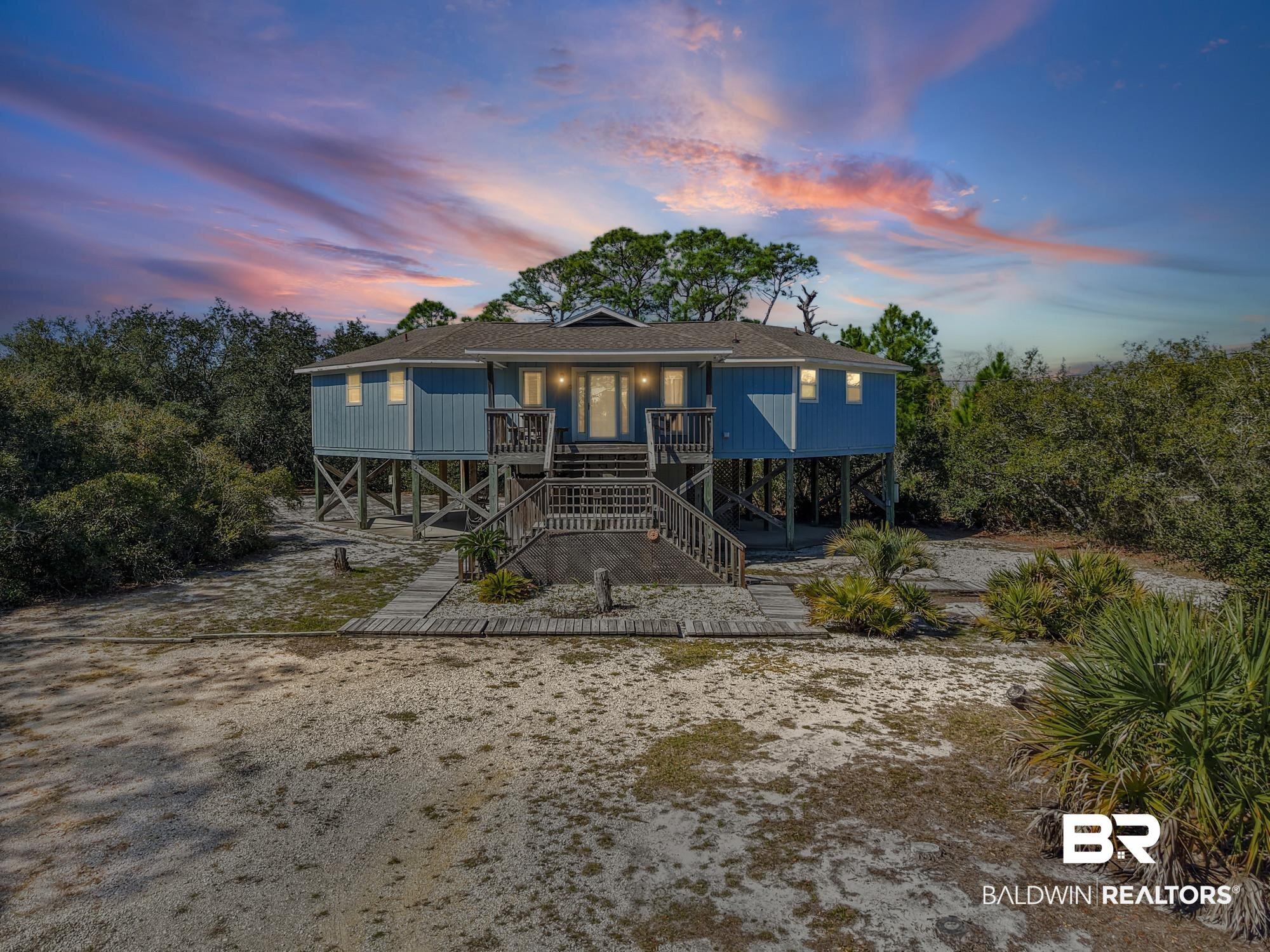 Image 2: Raised beach house featuring roof with shingles and a balcony