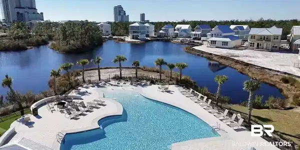 Image 2: Community pool with a water view, a patio, and a residential view